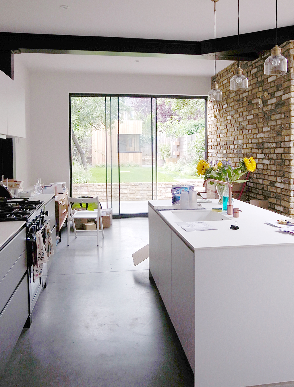 2018年7月に竣工したロンドンの住宅のキッチンダイニング・エリア。コンクリート・フロアのパティオと一続きになっていて、自由に行き来ができる