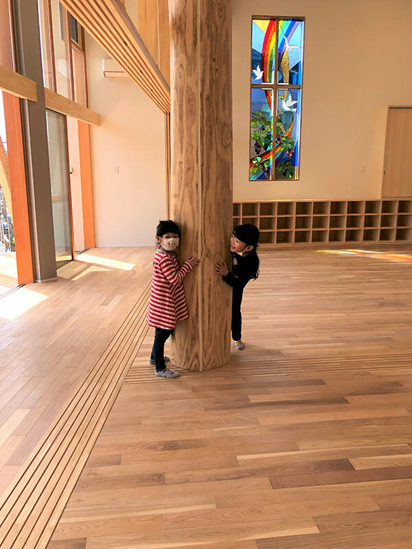 1、2歳の保育室にある丸太柱に触る子どもたち