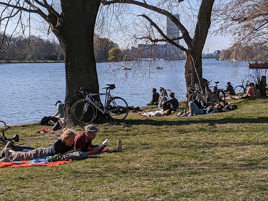 シュプレー川沿いの公園でシートを敷きくつろぐ人々