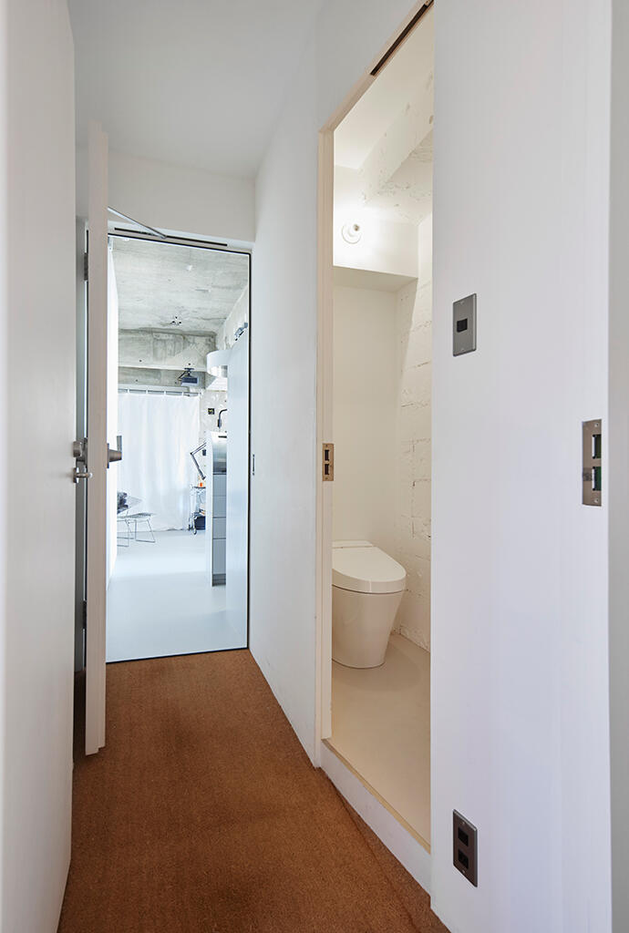 アプローチの廊下の幅を変えてトイレを格納、一室空間内からはトイレは外した。